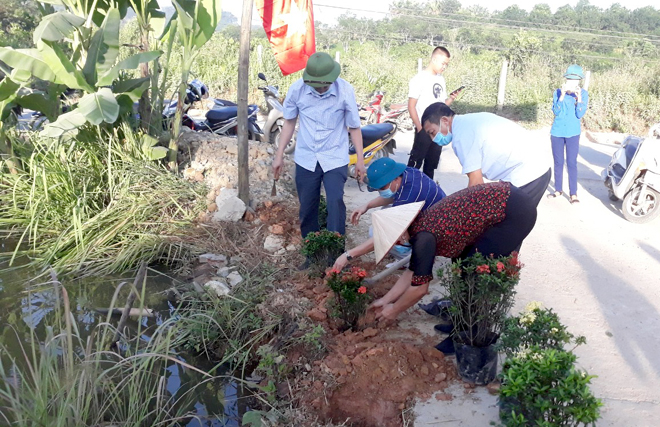 Cán bộ, đảng viên Chi bộ thôn Làng Cần tham gia trồng hoa đường thôn trong hoạt động “Ngày cuối tuần cùng dân”.